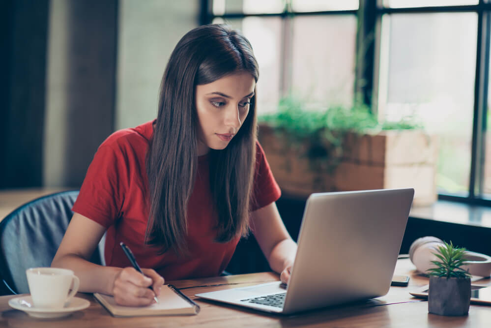 A woman working on her laptop in a coffee shop