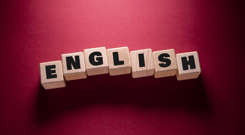 The word english spelled out in wooden blocks on a red background