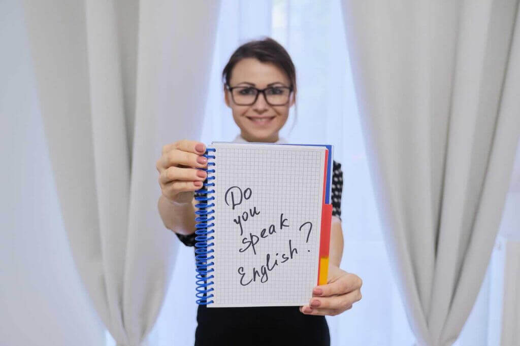 A woman holding up a notebook with a note on it