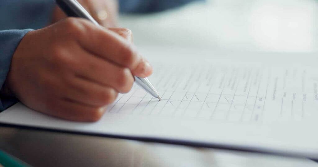 Close up of a person filling out a questionnaire with a pen